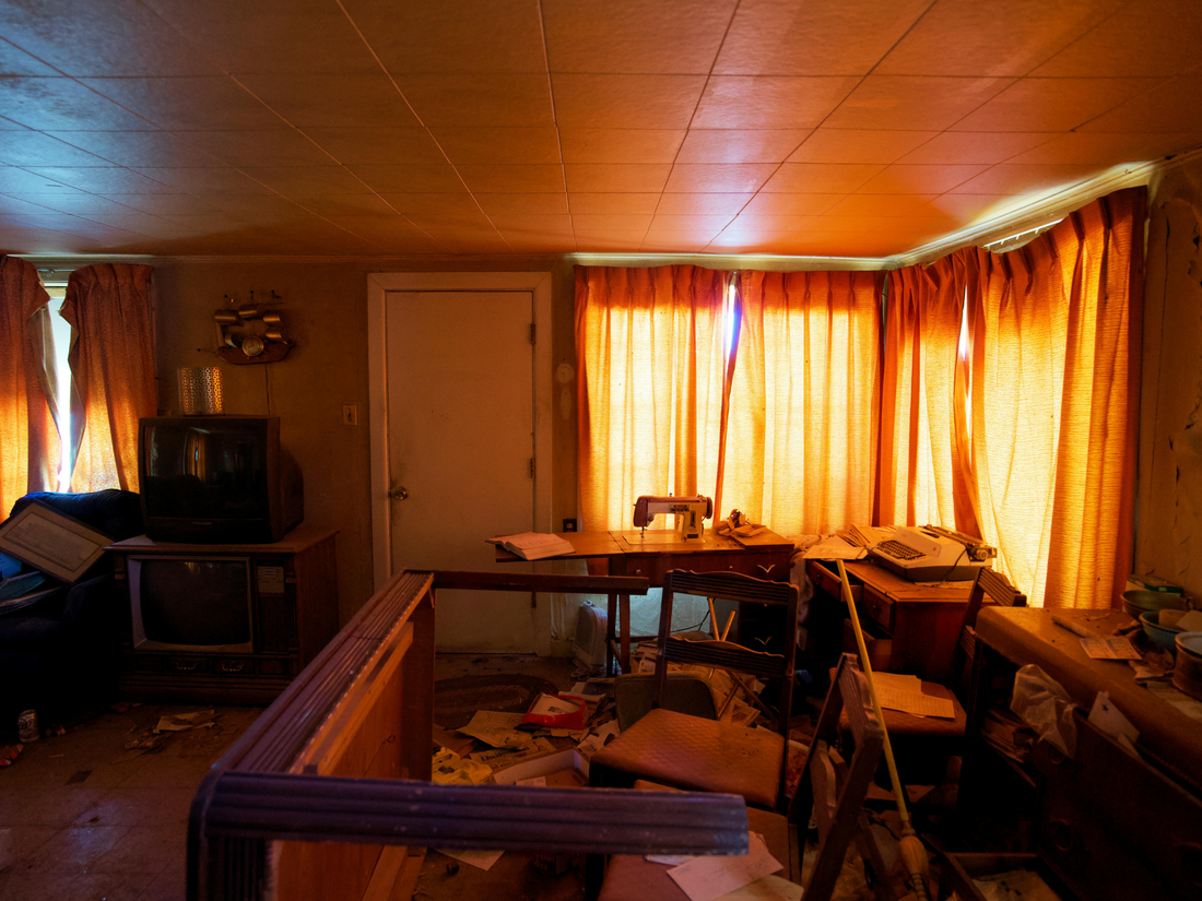 Cluttered living room filled with belongings before professional hoarding clean-up service